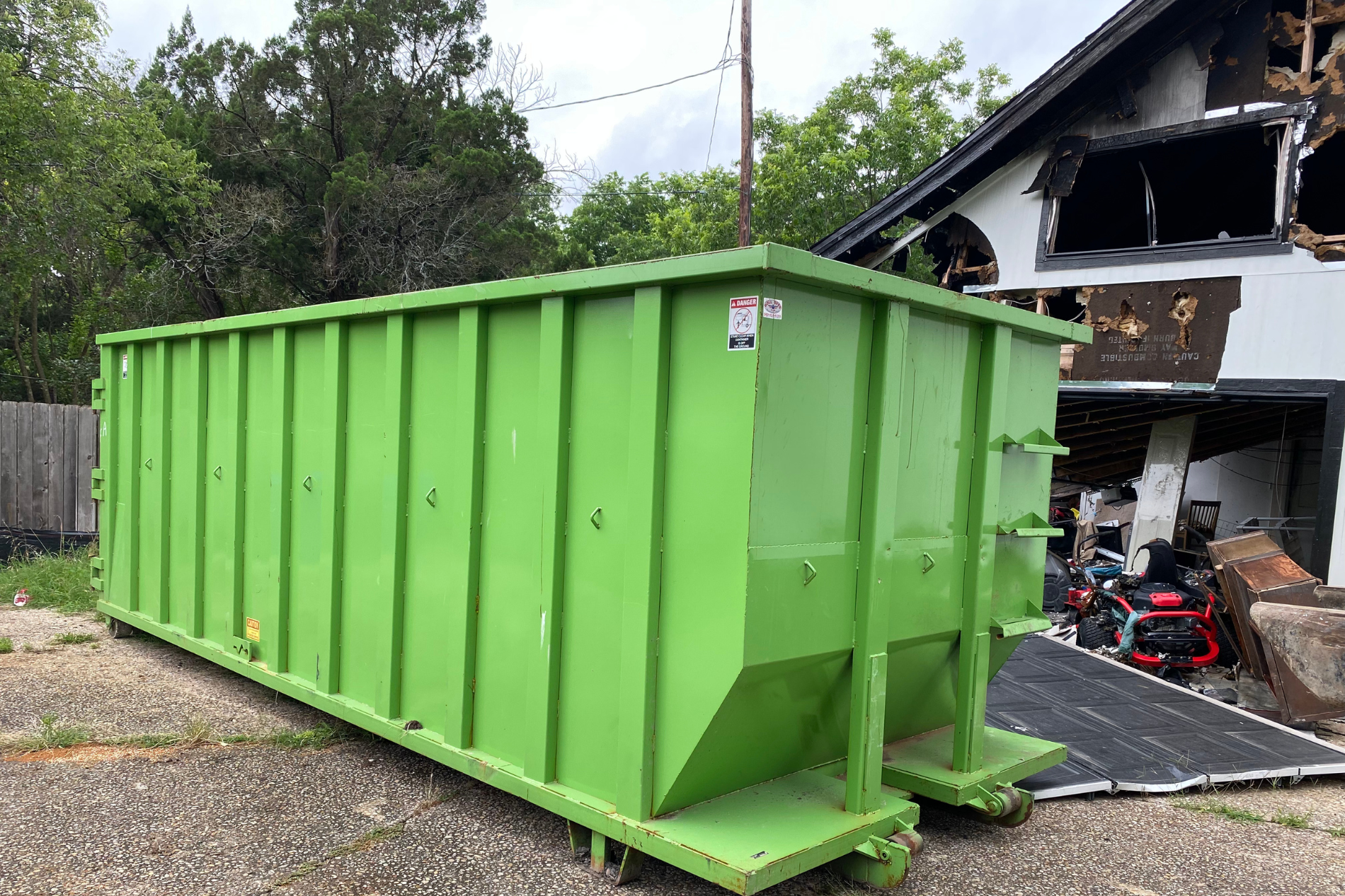Green dumpster by home demolition