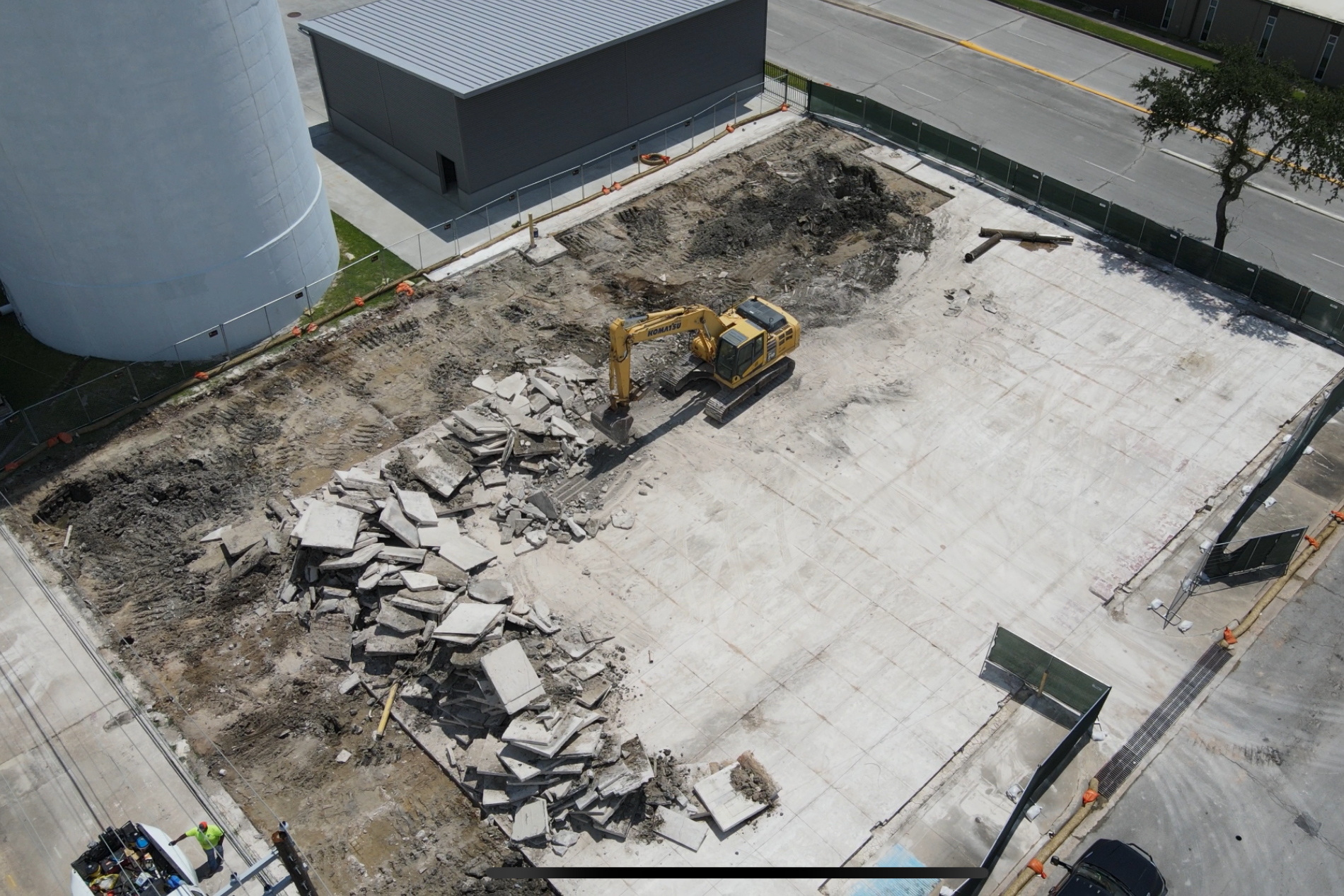 Excavator clearing debris in building lot