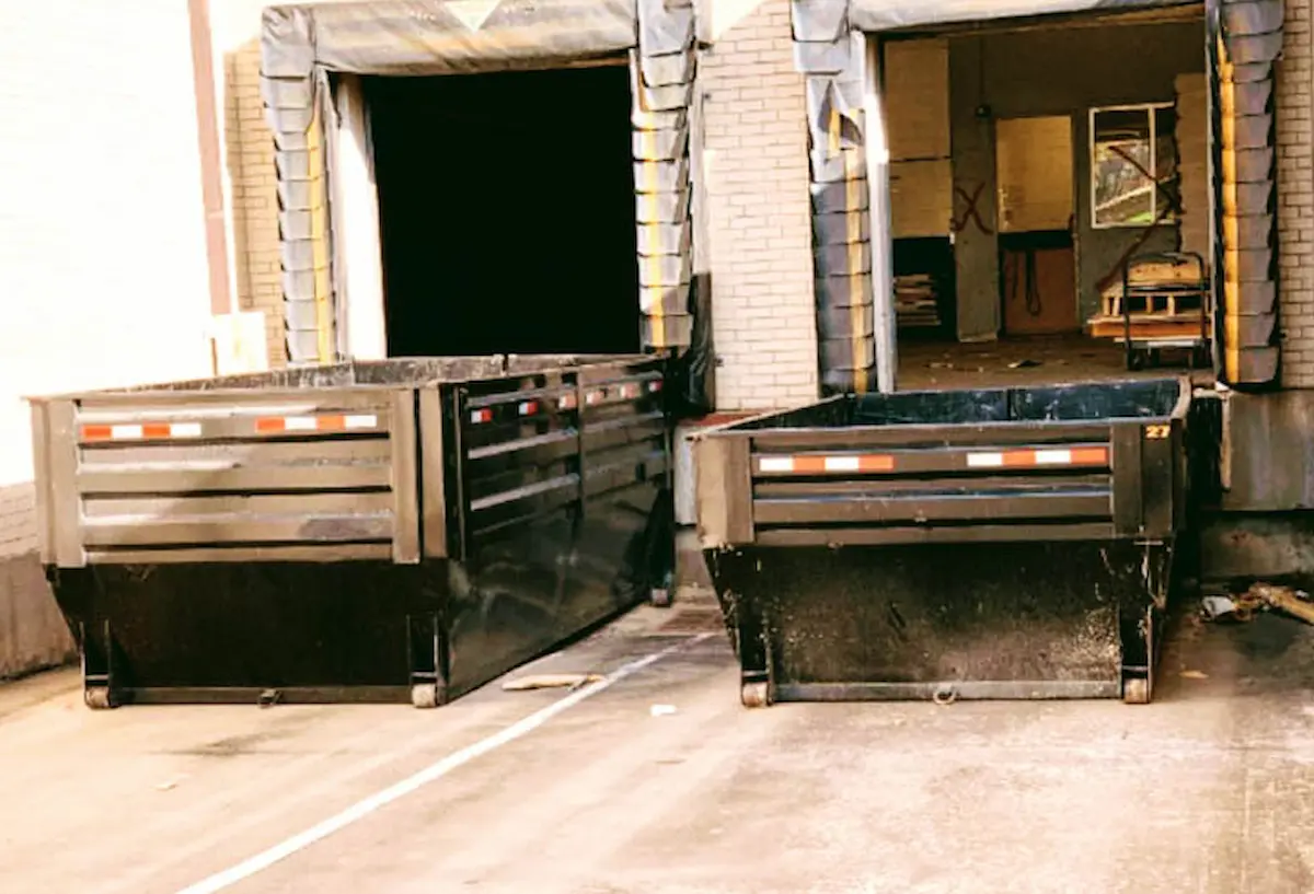 2 black roll-off dumpsters